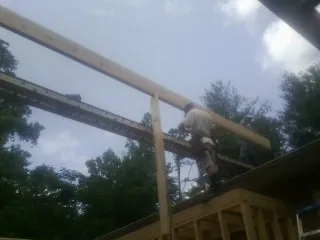 Carpenter setting a ridge beam over a new addition frame — Ice Dam Removal by Roofing Brothers in Cumberland